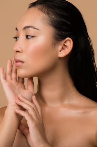 Asian American woman touching her face
