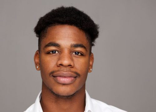 Man wearing a white shirt against a gray background