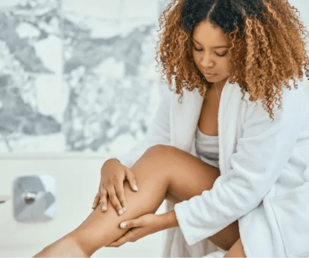 Woman touching her legs by a bath tub