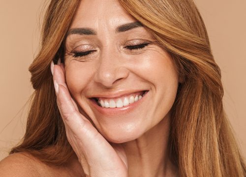 Smiling White woman touching the side of her face