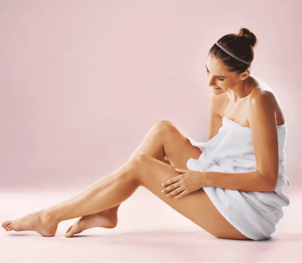 Woman wearing a towel touching her legs