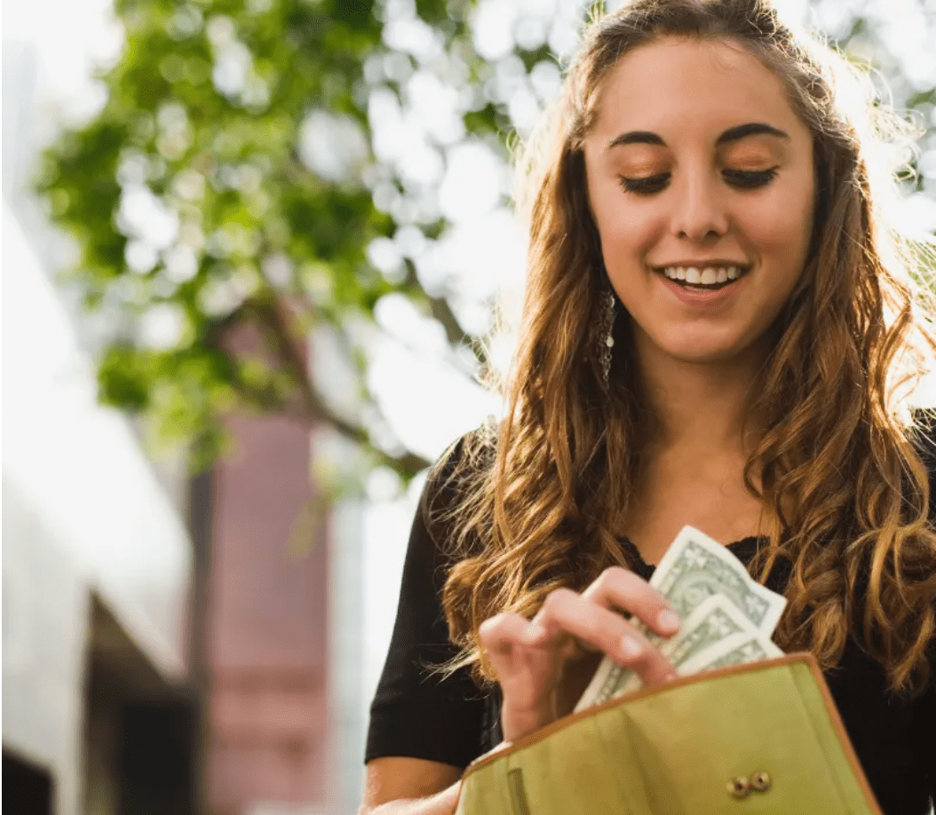 Woman pulling out cash from her wallet