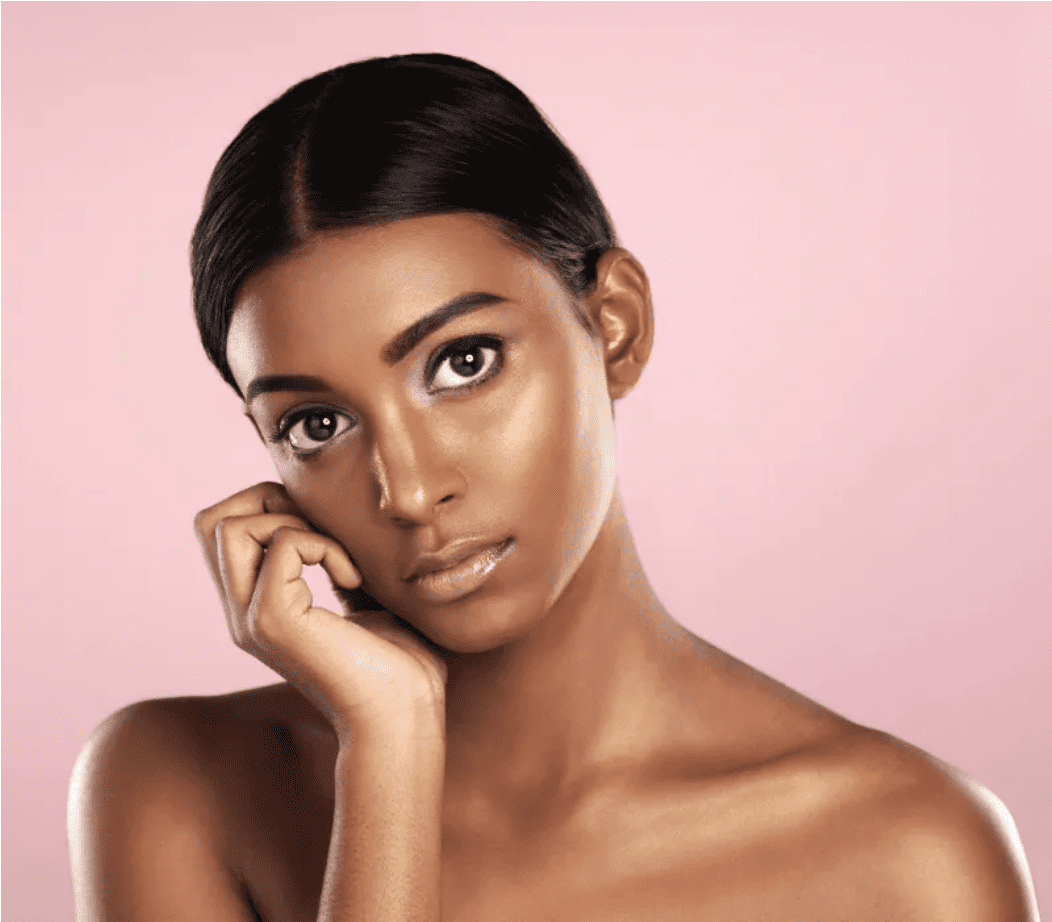 Woman touching the side of her face against a pink background