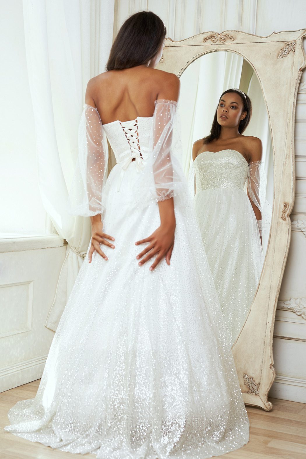 Bride looking at herself in the mirror in her wedding dress