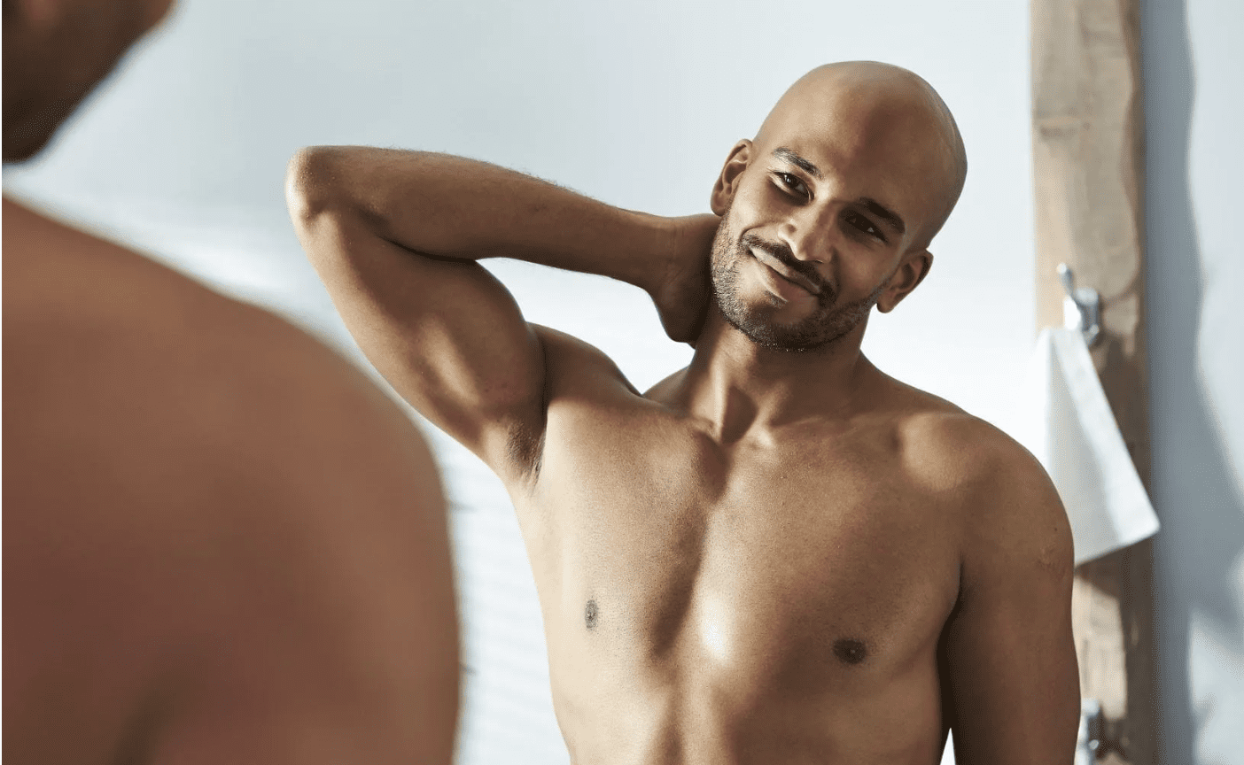 Shirtless Black man showing up a hairless armpit