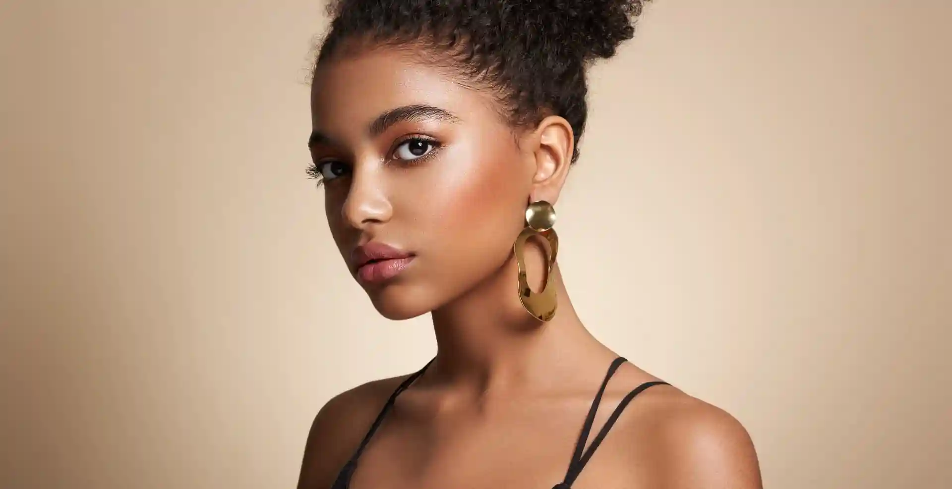 Chic, beautiful woman wearing big, gold earrings